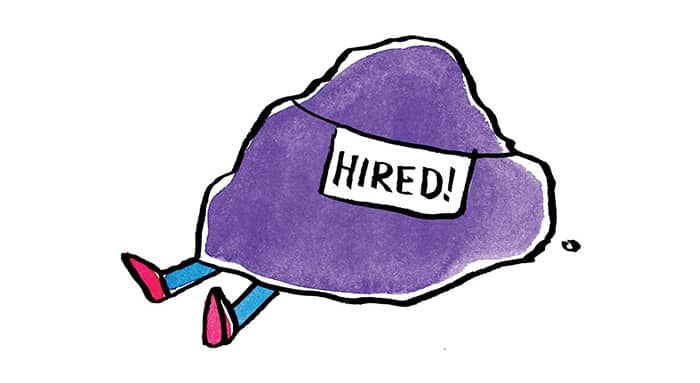 A persons legs sticking out from under a purple rock with a flag that says hiring on it 